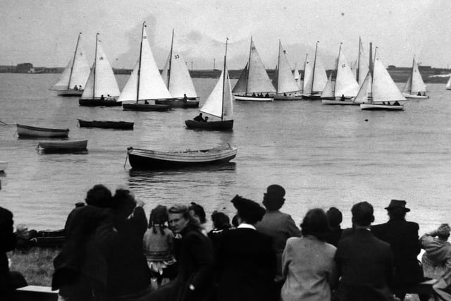 A regatta at Lock Lake, Eastney.
Spectators in front of the Thatched House pub at Milton Locks enjoy a regatta of sloop rigged dinghies.  Picture: Alan Cunningham collection.