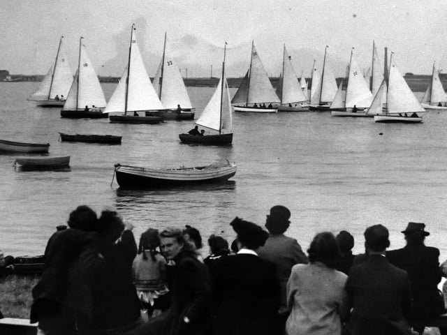 A regatta at Lock Lake, Eastney.
Spectators in front of the Thatched House pub at Milton Locks enjoy a regatta of sloop rigged dinghies.  Picture: Alan Cunningham collection.
