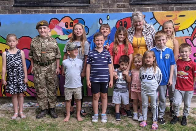 Margaret Lowther with some of the children from the neighbourhood in front of the new mural. Picture: Emily Turner