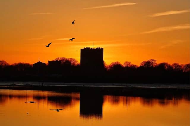 The sun setting behind Portchester Castle. Picture: Trev Harman