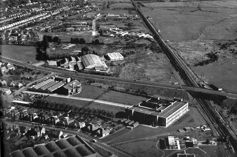 An aerial view looking east over the Eastern Road. This fine photo sent in by David Watts, of Farlington, shows the changes to the area since the 1950s when this shot was taken.
To the bottom of the photo is the Portsmouth Co-op bakery and dairy, and above that, the Twilfit corset factory. Do you remember passing it on the train and seeing the word TWILFIT planted out in shrubbery? It can be seen in the photo just below the railway bridge. Under the bridge can be made out the railway sidings now long gone. The Eastern Road seems very quiet with no side roads leading off it unlike today. Dunham Bush's factory with the arched roof is to the centre and, above that, can be seen Fitzherbert Road ending in a cul-de-sac. The Sainsbury's store is now built over the site of Dunham Bush. To the right the quiet of the marshes has been reclaimed to a certain extent and now has the roaring traffic on the motorway running parallel with the railway line, which can be seen disappearing into the distance. In the top-left-hand corner alongside the Portsdown Hill Road can be seen Sunspan, the well known white painted house overlooking everything.