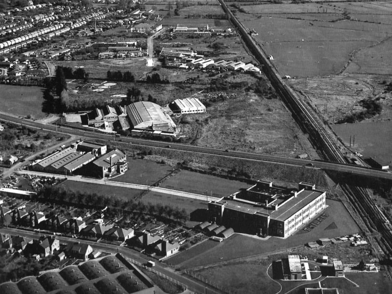 An aerial view looking east over the Eastern Road. This fine photo sent in by David Watts, of Farlington, shows the changes to the area since the 1950s when this shot was taken.
To the bottom of the photo is the Portsmouth Co-op bakery and dairy, and above that, the Twilfit corset factory. Do you remember passing it on the train and seeing the word TWILFIT planted out in shrubbery? It can be seen in the photo just below the railway bridge. Under the bridge can be made out the railway sidings now long gone. The Eastern Road seems very quiet with no side roads leading off it unlike today. Dunham Bush's factory with the arched roof is to the centre and, above that, can be seen Fitzherbert Road ending in a cul-de-sac. The Sainsbury's store is now built over the site of Dunham Bush. To the right the quiet of the marshes has been reclaimed to a certain extent and now has the roaring traffic on the motorway running parallel with the railway line, which can be seen disappearing into the distance. In the top-left-hand corner alongside the Portsdown Hill Road can be seen Sunspan, the well known white painted house overlooking everything.