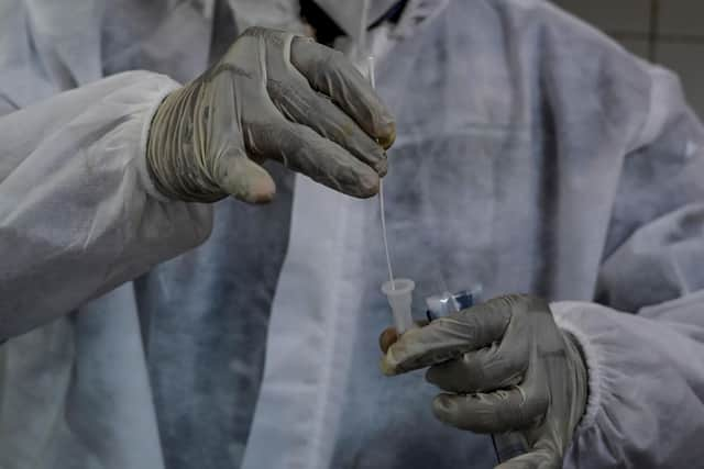 A health worker dips a nasal swab sample into a testing solution during a Covid-19 coronavirus test Picture: Indranil Mukherjee / AFP via Getty Images