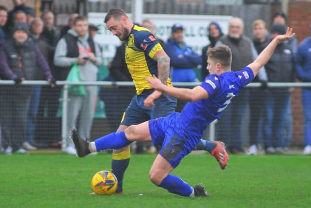 Baffins defender Rhys Lloyd slides in to challenge Moneyfields striker Steve Hutchings. Picture: Martyn White