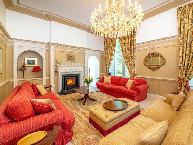 Here you can see the drawing room, boasting an impressive chandelier. The drawing room has amazing wood panelling throughout and an "intriguing archway" through to the garden room according to the description