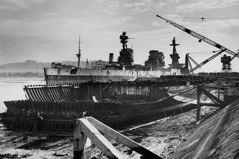 In the foreground lays the broken hull of the Royal Navy Nelson-class battleship HMS Rodney which had played a major role in the sinking of the German battleship Bismarck during World War 2 whilst behind her in the process of being scrapped at the Thomas W Ward shipyard is her sister ship HMS Nelson and HMS Revenge on 4 September 1950 in Inverkeithing,Fife, Scotland, United Kingdom.  (Photo by Don Price/ Fox Photos/Hulton Archive/Getty Images).