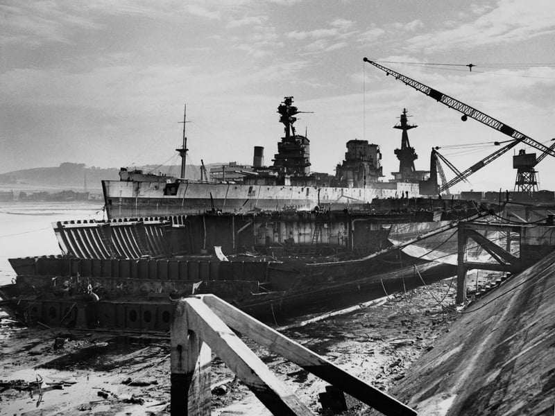 In the foreground lays the broken hull of the Royal Navy Nelson-class battleship HMS Rodney which had played a major role in the sinking of the German battleship Bismarck during World War 2 whilst behind her in the process of being scrapped at the Thomas W Ward shipyard is her sister ship HMS Nelson and HMS Revenge on 4 September 1950 in Inverkeithing,Fife, Scotland, United Kingdom. (Photo by Don Price/ Fox Photos/Hulton Archive/Getty Images).