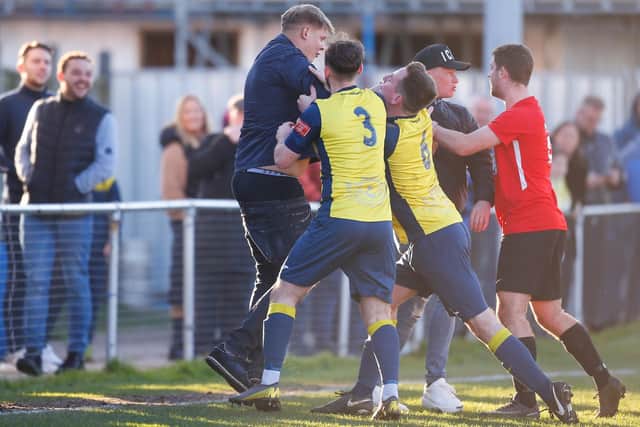 A second Fareham Town spectator encroaches onto the pitch before Moneyfields players attempt to push him back. Picture: Dave Bodymore.