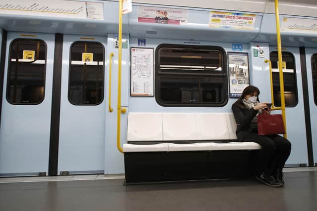 A woman wearing a face mask checks her phone in a subway in Milan, Italy. Picture: AP Photo/Antonio Calanni