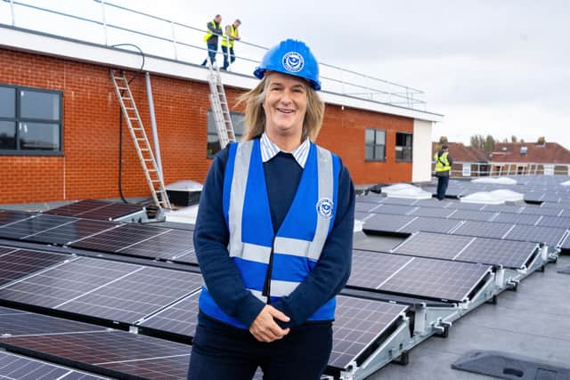 Clare Martin - CEO of Pompey in the Community on top of the John Jenkins stadium, with new solar panels being installed. Photo by Matt Clark