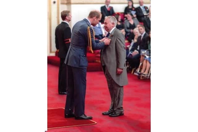 Iain Shepherd receives his MBE from Prince William during a ceremony at Buckingham Palace.