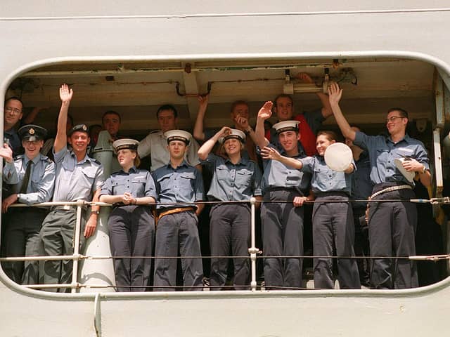 Members of the ship's company of HMS Invincible wave to their families as the ship comes alongside in Portsmouth in 1999. Picture: Pete Langdown. The News 992543-2.