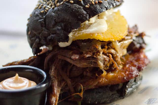 Huis's Beef brisket slow cooked in Mongozo Banana beer, topped with Gruyère cheese, sweet potato rosti, caramelised pineapple in a toasted brioche bun - with a side of Sriracha mayo.