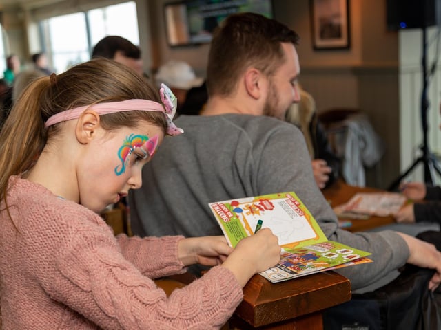 Emily Richards (7) making the most of the free colouring in book in the children's goodie bag. Picture: Mike Cooter (040323)