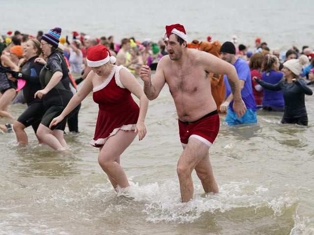 People take part in the Gosport New Year's Day Dip in The Solent at Stokes Bay, Gosport, Hampshire, to raise money for Gosport and Fareham Inshore Rescue Service.