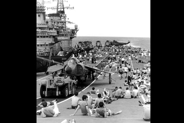 Staff on board HMS Hermes sunbathing on the flight deck as the naval task force heads for the Falkland Islands following the Argentinian invastion, April 1982. (Photo by Martin Cleaver/Pool/Getty Images)