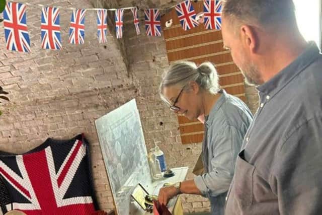 Gordon Cross looks on as Lisa Smith sees for the first time the medals won by her great uncles