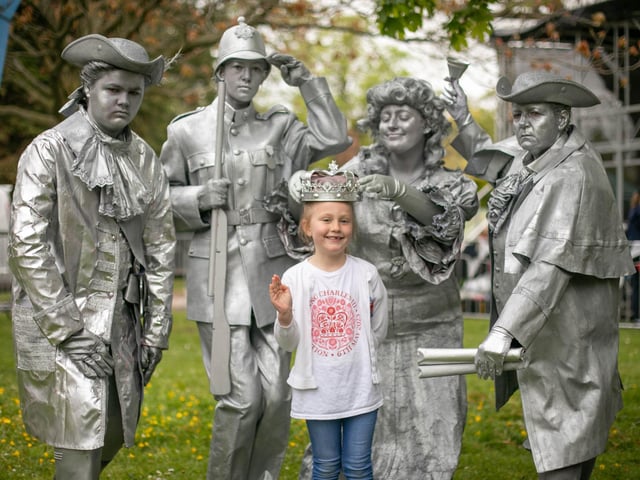 Ella, six, with the silver statues of The Young Creatives at Victoria Park