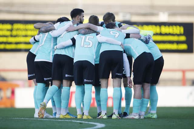 The Pompey players in a huddle before their disappointing draw at Morecambe