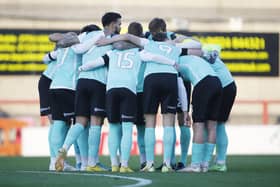 The Pompey players in a huddle before their disappointing draw at Morecambe