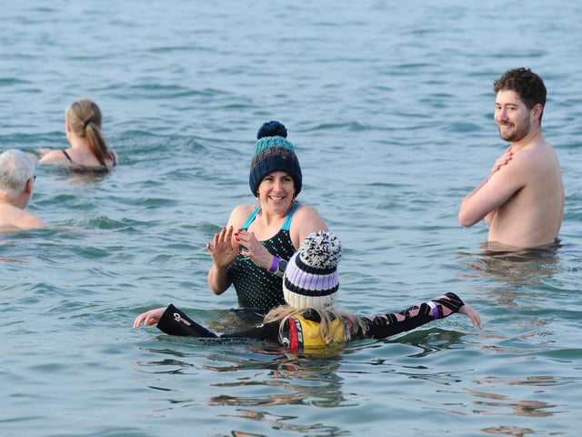 While some wore wetsuits, many took to the water in swimming trunks and bathing suits. Picture: Sarah Standing (261224-513)