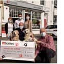 Pictured centre is Allen Parton from Hounds For Heroes, with his two assistance dogs EJ and Rookie, surrounded by members of the Homes team who donated £1,250 to the charity