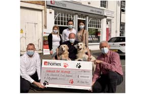 Pictured centre is Allen Parton from Hounds For Heroes, with his two assistance dogs EJ and Rookie, surrounded by members of the Homes team who donated £1,250 to the charity