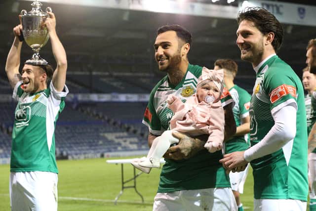 Moneyfields celebrate winning the Portsmouth Senior Cup on penalties with one of their youngest supporters. Picture: Chris Moorhouse