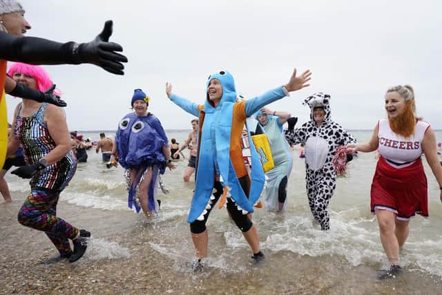 People take part in the Gosport New Year's Day Dip in The Solent at Stokes Bay, Gosport, to raise money for Gosport and Fareham Inshore Rescue Service.