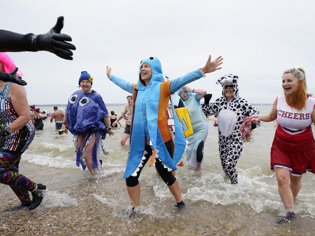 People take part in the Gosport New Year's Day Dip in The Solent at Stokes Bay, Gosport, Hampshire, to raise money for Gosport and Fareham Inshore Rescue Service.