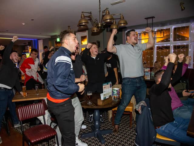 Fans in Cosham's Red Lion pub elebrate England scoring against Senegal in the last 16 match of the Fifa World Cup 2022. 

Photos by Alex Shute