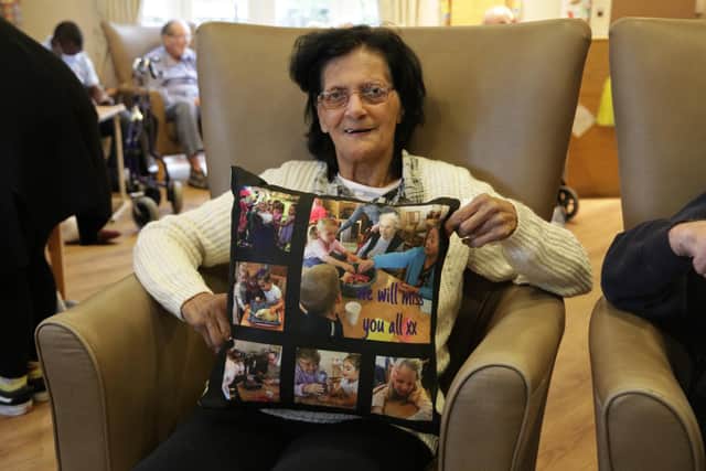 Children from Growing Places nurseries visited their friends at local nursing homes to give them gifts just before lockdown. Pictured: Irene from Woodlands Care Home with one of the cushions created by the kids