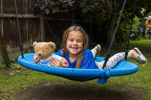Bella Champion on her favourite swing chair with training bear Rufus. Picture: Mike Cooter (150721)