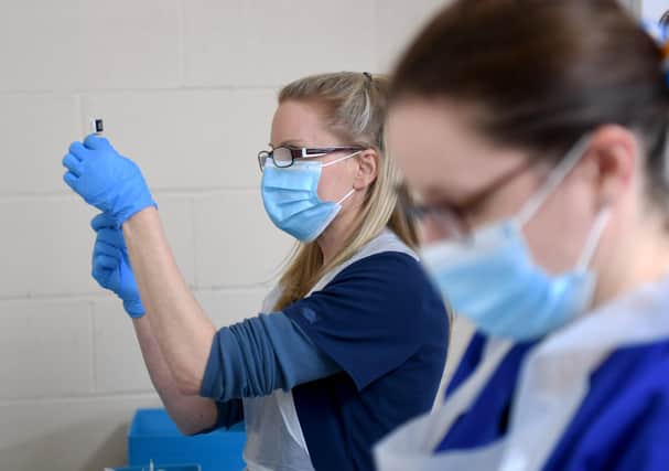 Nurses Sarah Anderson (left) and Amy Addison mix the Pfizer vaccines so they are ready to use. Picture by Simon Hulme
