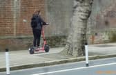 A Voi scooter being rode on the pavement on Ordnance Road, Portsea in May 2022