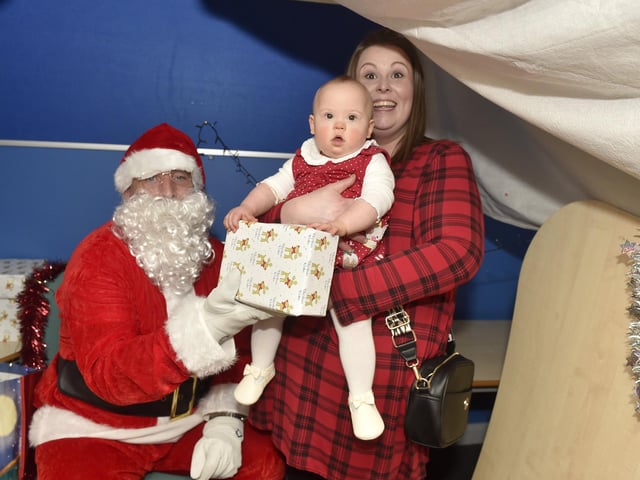 Beacon View Primary Academy in Paulsgrove held their annual community Christmas lunch on Friday, December 22.Pictured is: Joanne Parfitt with her daughter Hermione Toovey (10 months old) meeting Father Christmas.Picture: Sarah Standing (221223-4086)