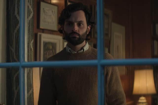 Penn Badgley as Joe Goldberg in You, watching through a window (Credit: Netflix)
