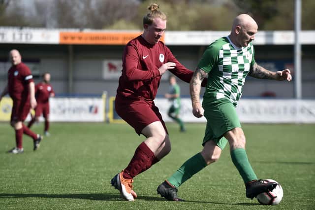 Callum French (Burrfields, maroon) keeps a close eye on Mob striker Andy Brown. Picture: Allan Hutchings