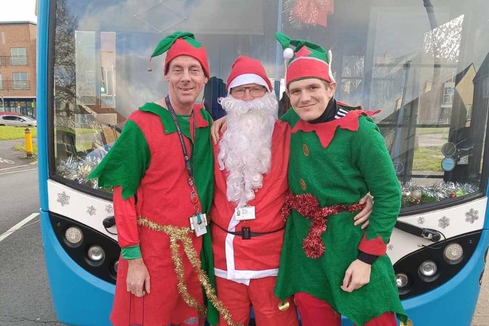 Santa and his elves in front of the Santa Bus