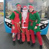 Santa and his elves in front of the Santa Bus