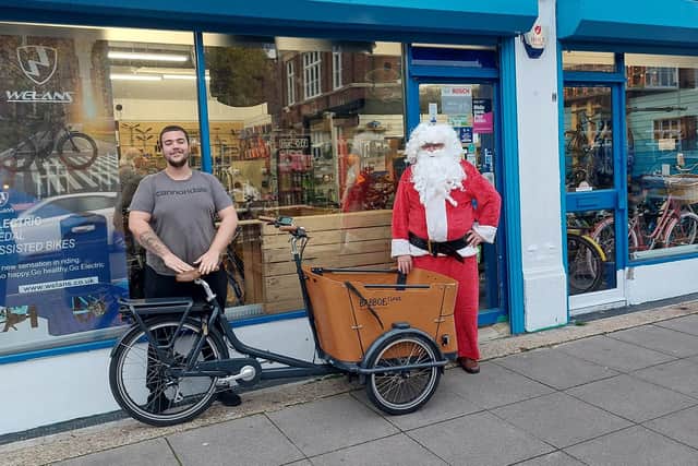 Father Christmas accepts the loan of a bike from Southsea Cycles on behalf of Gosport Rotary Club