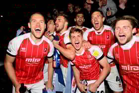 CHELTENHAM, ENGLAND - APRIL 27: Players and fans of Cheltenham Town celebrate their side's victory outside the ground as they gain promotion to the Sky Bet League One after the Sky Bet League Two match between Cheltenham Town and Carlisle United at The Jonny-Rocks Stadium on April 27, 2021 in Cheltenham, England. Sporting stadiums around the UK remain under strict restrictions due to the Coronavirus Pandemic as Government social distancing laws prohibit fans inside venues resulting in games being played behind closed doors.  (Photo by Dan Mullan/Getty Images)