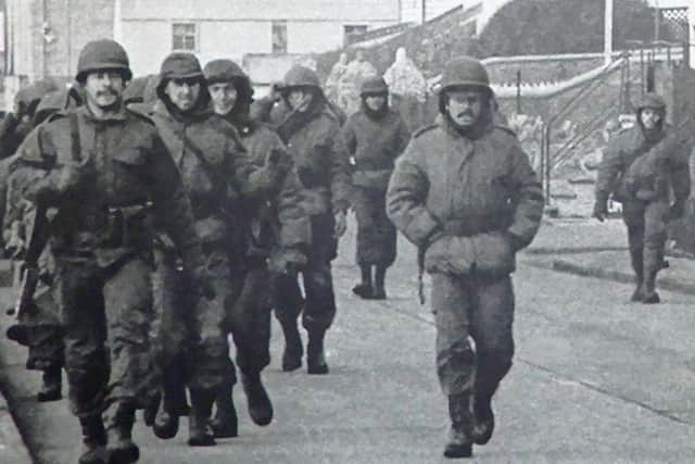 Argentine soldiers stroll down a street in Port Stanley. Little did they know what was to hit them. 