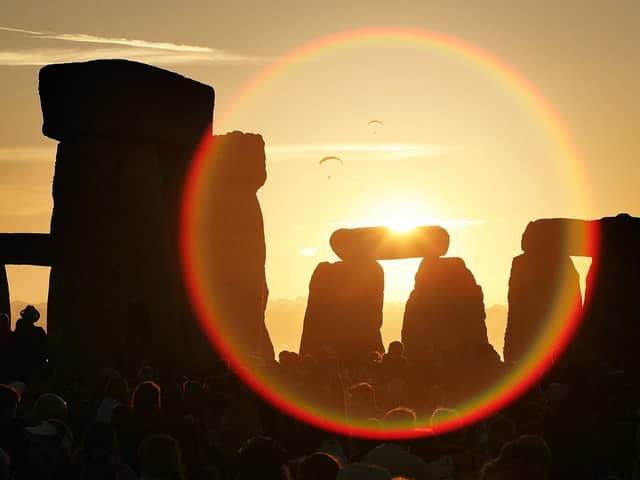 People watch the sun as it rises over Stonehenge to celebrate the Summer Solstice - one of the most popular places to watch the sunrise. However many are expected to watch it rise at Buster Hill this year (Photo by Peter Macdiarmid/Getty Images)
