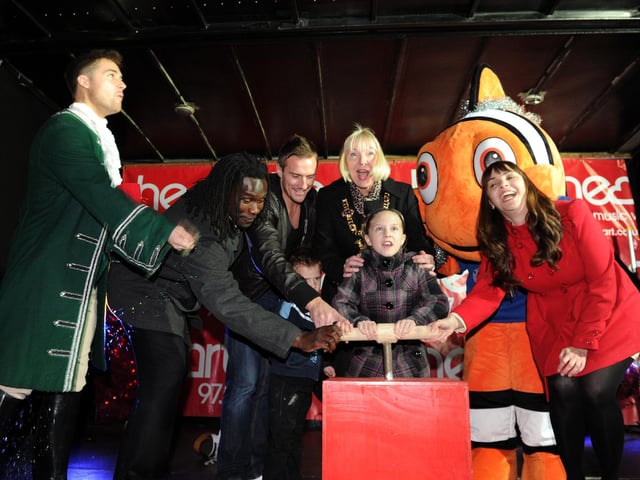 Commercial Road Christmas lights switch on in Portsmouth.    Pictured L-R Marcus Patric, Linvoy Primus, Pompey captain Liam Lawrence with his son Thomas, Lord Mayor Cheryl Buggy, Imogen Rogers 10, Charlie the Clown Fish from Blue Reef and the Face of Cascades Rachel Malley. Picture: Paul Jacobs (114102-10)