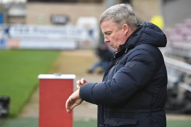 Pompey boss Kenny Jackett checks his watch at Northampton on Saturday.