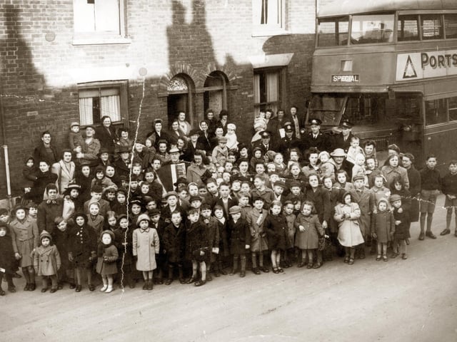 Residents gather in Buckland, Portsmouth, with 'Bunky Doo-dalee-do', real name Alfred Nicholson. The image was taken in 1945 in Sultan Road.
He used to help run the boys’ club in Fratton Road, opposite St Mary's Church. He was well known for his Meccano skills and made a large model of either the Queen Mary ship or the Queen Elizabeth. He was always involved in raising money for some cause, he volunteered as much as physically able. He played his accordion at parties
and to the queues outside cinemas and sold the Football Mail at the top of Sultan Road.
Picture: Courtesy of Brian Duke