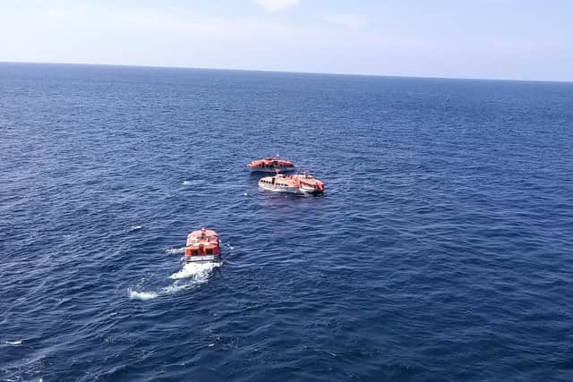 Lifeboats waiting to come alongside the liner during passenger and stores transfer at Phuket, Thailand.