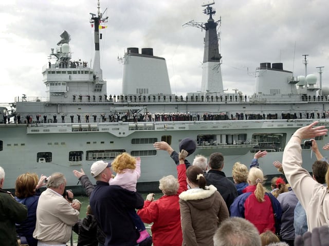 Royal Navy aircraft carrier HMS Invincible leaving Portsmouth Harbour with a large crowd of people gathered on the Round Tower at Old Portsmouth to watch the ship sail out. 6th May 2004. Picture: Michael Scaddan (042274-0041)