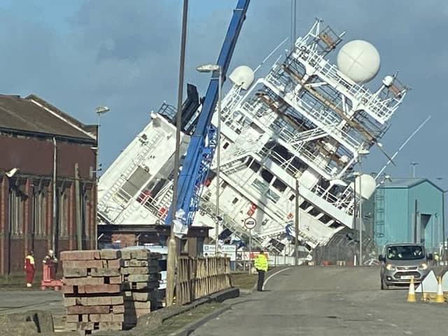 A ship is currently leaning towards the docks at a worrying angle in Leith, Edinburgh. (Photo credit: @Tomafc83 on Twitter)